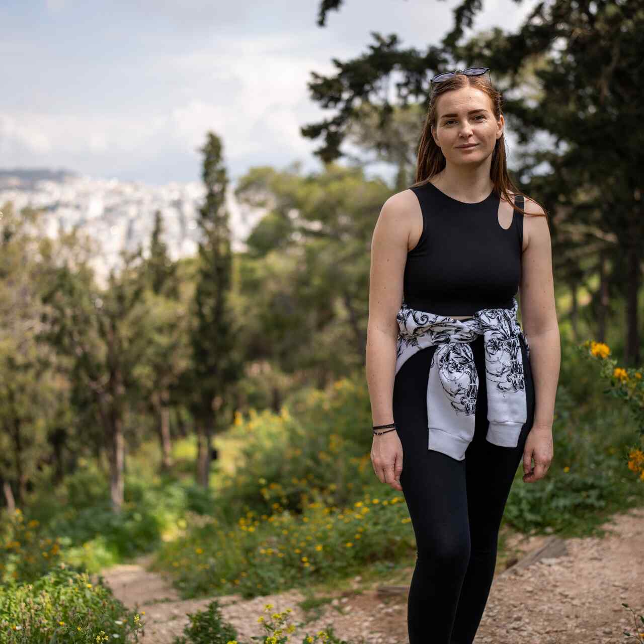 Khrystyna stands tall and poses for a picture in a forest.